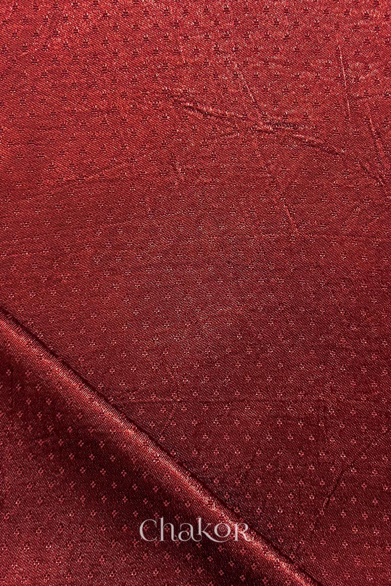 brick red mashru self textured fabric with folded corner & Chakor brand watermark.
