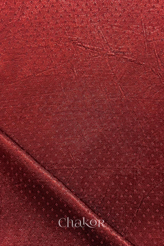 brick red mashru self textured fabric with folded corner & Chakor brand watermark.
