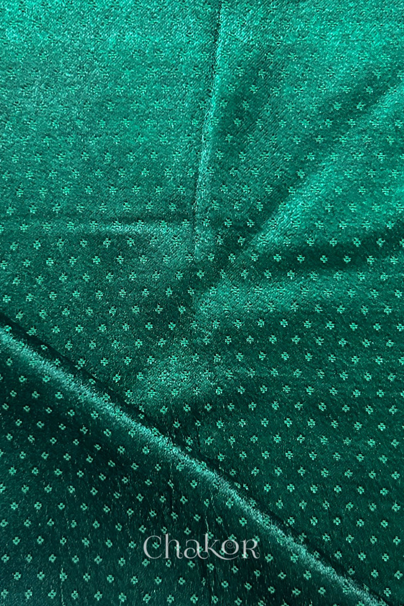 dark green mashru self textured fabric with folded corner & Chakor brand watermark.
