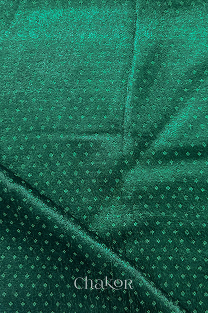 Dark green mashru self textured fabric with folded corner & Chakor brand watermark.
