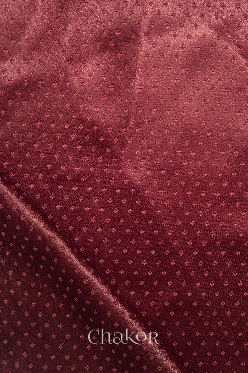 maroon mashru self textured fabric with folded corner & Chakor brand watermark.
