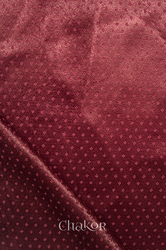 maroon mashru self textured fabric with folded corner & Chakor brand watermark.
