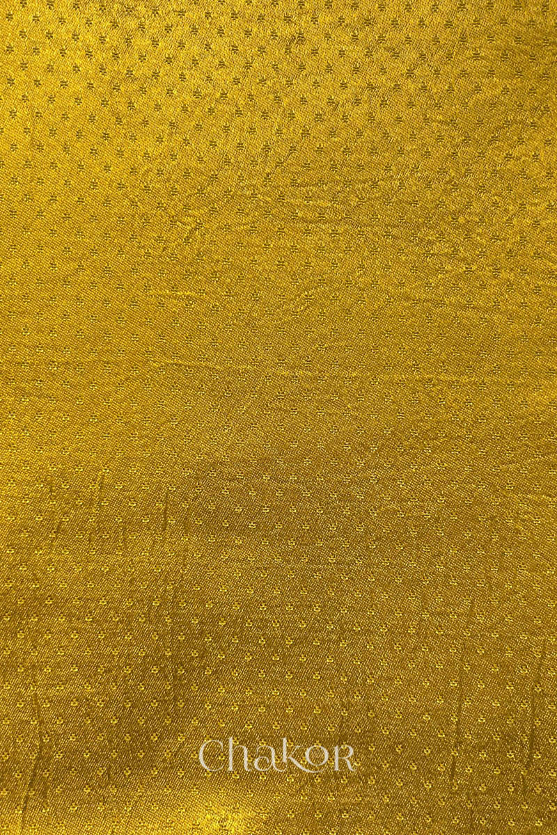 mustard yellow mashru self textured fabric with 'Chakor' logo visible.
