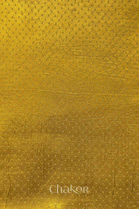 mustard yellow mashru self textured fabric with 'Chakor' logo visible.
