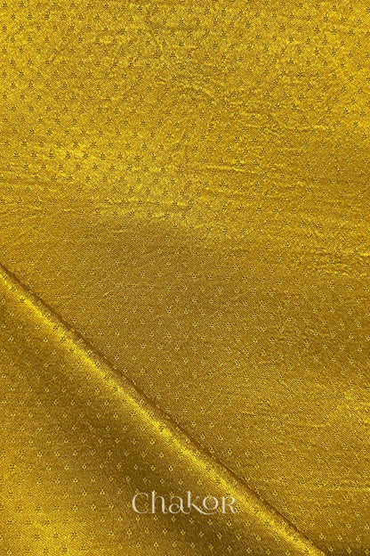 mustard yellow mashru self textured fabric with folded corner & Chakor brand watermark.
