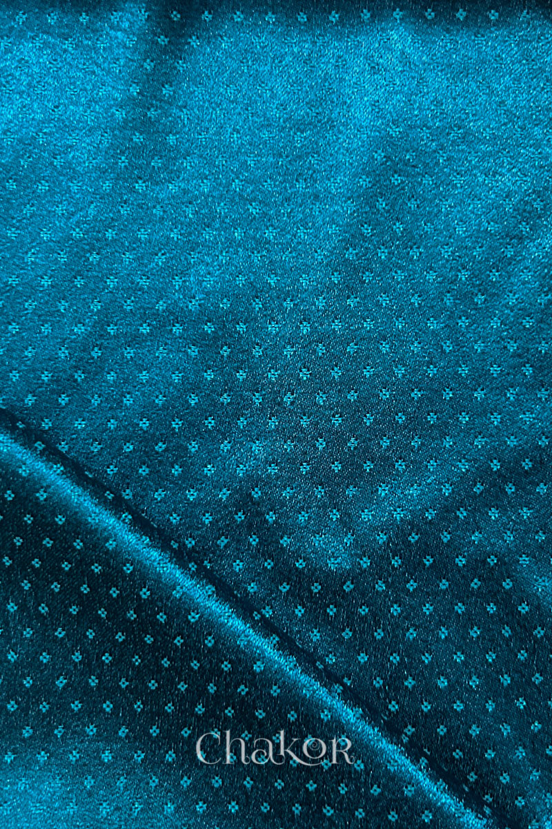 deep indigo mashru self textured fabric with folded corner & Chakor brand watermark.
