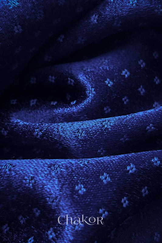 Close-up of royal blue mashru self textured fabric with 'Chakor' logo visible.