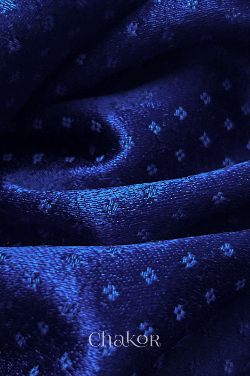 Close-up of royal blue mashru self textured fabric with 'Chakor' logo visible.