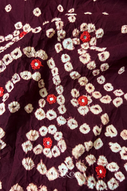 Close-up of Popat Bandhani motifs and hand-embroidered mirror work on Maroon blouse fabric.
