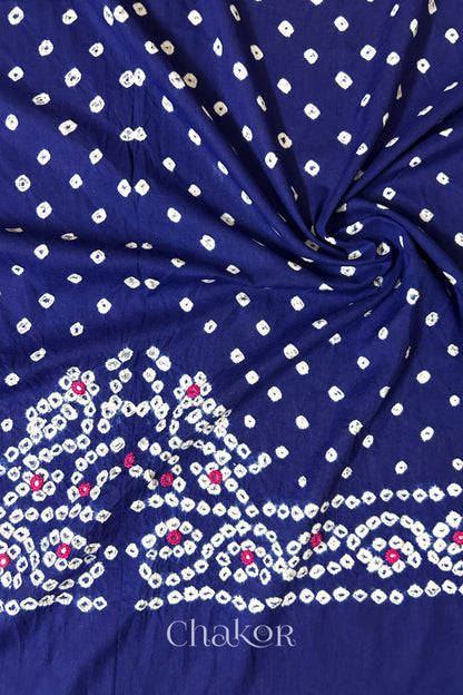 Navy blue Bandhani cambric cotton blouse fabric showing its soft drape and hand-tied pattern.
