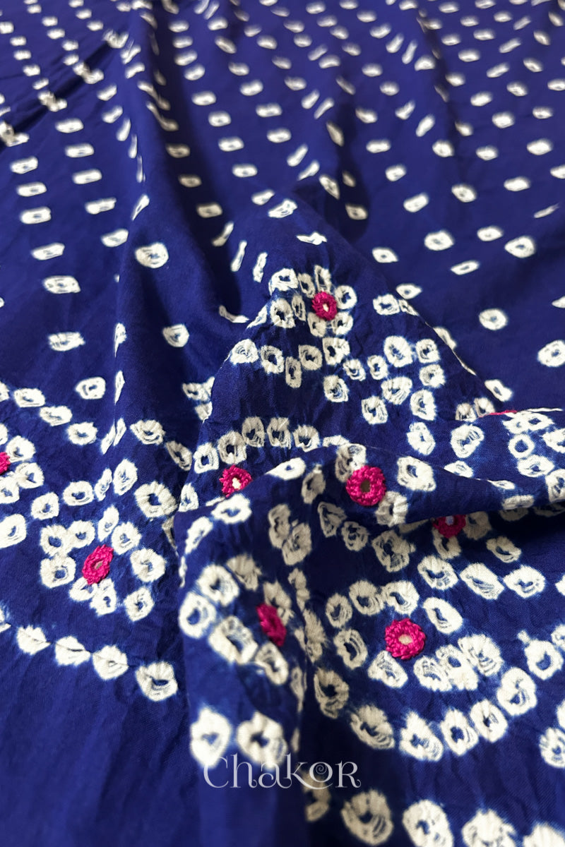 Close-up of Popat Bandhani motifs and hand-embroidered mirror work on Navy blue blouse fabric.
