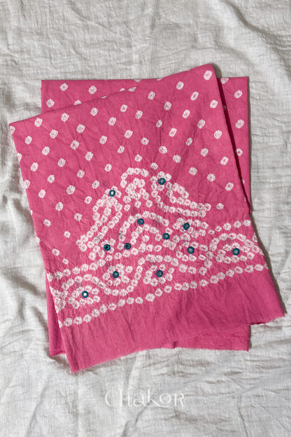 Pink Kutch Bandhani cambric cotton unstitched blouse piece folded on white fabric.
