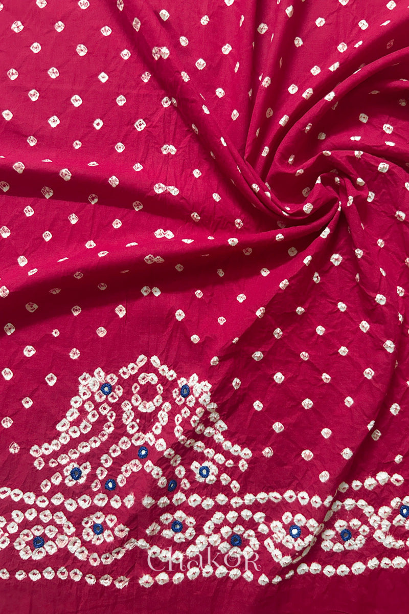 Strawberry pink Bandhani cambric cotton blouse fabric showing its soft drape and hand-tied pattern.
