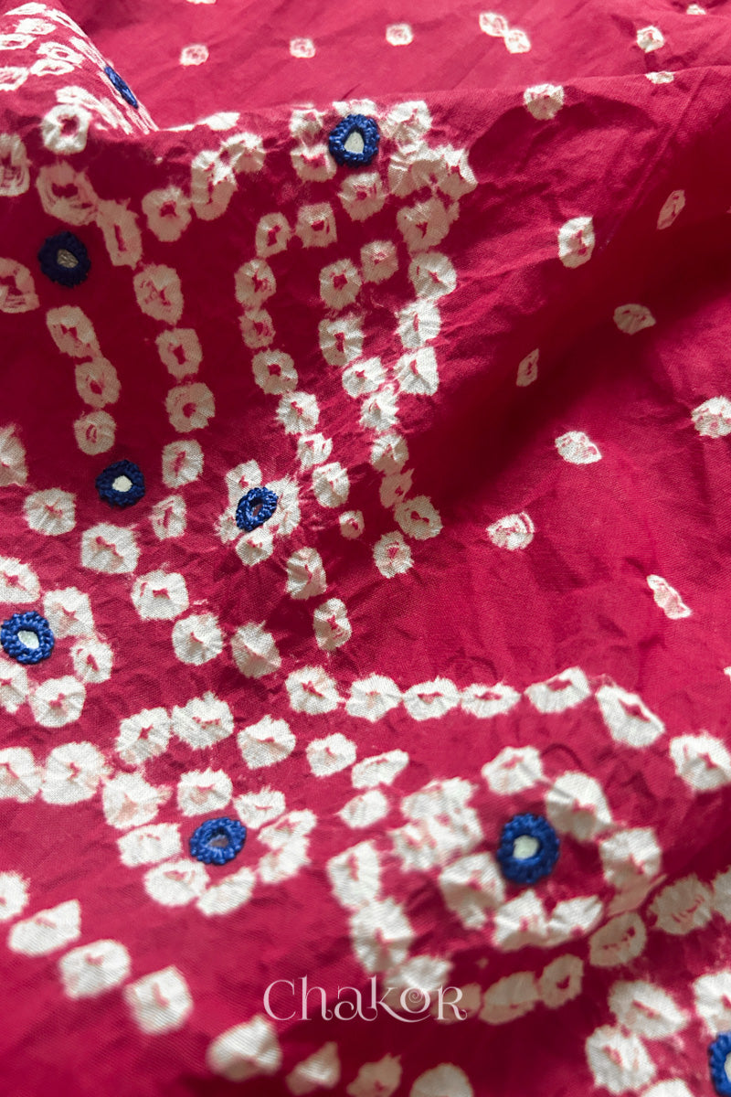 Close-up of Popat Bandhani motifs and hand-embroidered mirror work on Strawberry pink blouse fabric.
