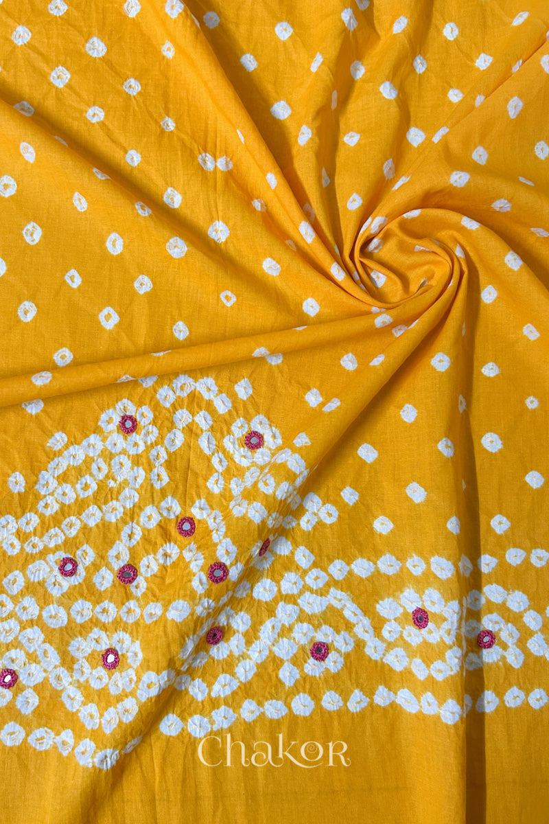 Yellow Bandhani cambric cotton blouse fabric showing its soft drape and hand-tied pattern.
