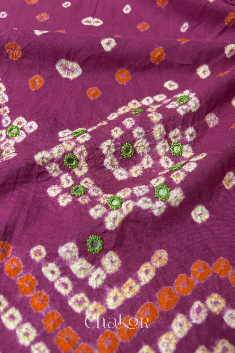 Detail of Kutch Bandhani Keri pattern with mirror embroidery on Magenta cotton blouse fabric.
