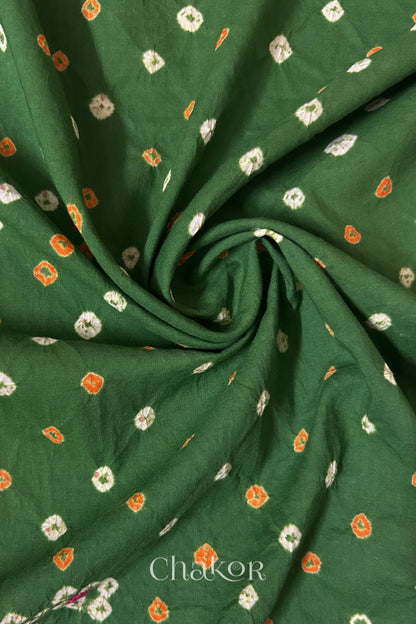 Mehendi Green Bandhani cotton blouse fabric showing fine tie-dye dots and its soft drape.

