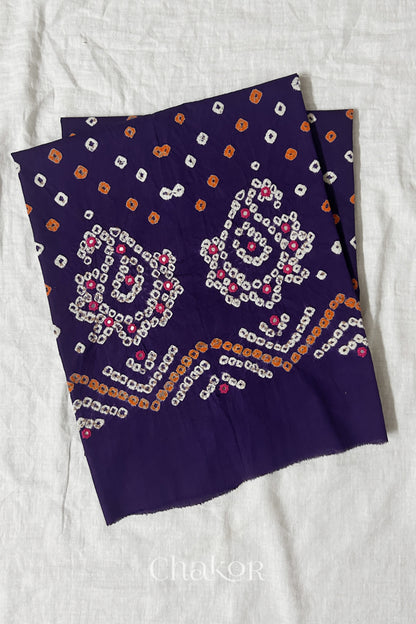 Purple Kutch Bandhani cotton unstitched blouse fabric with Keri pattern piece folded on white fabric.
