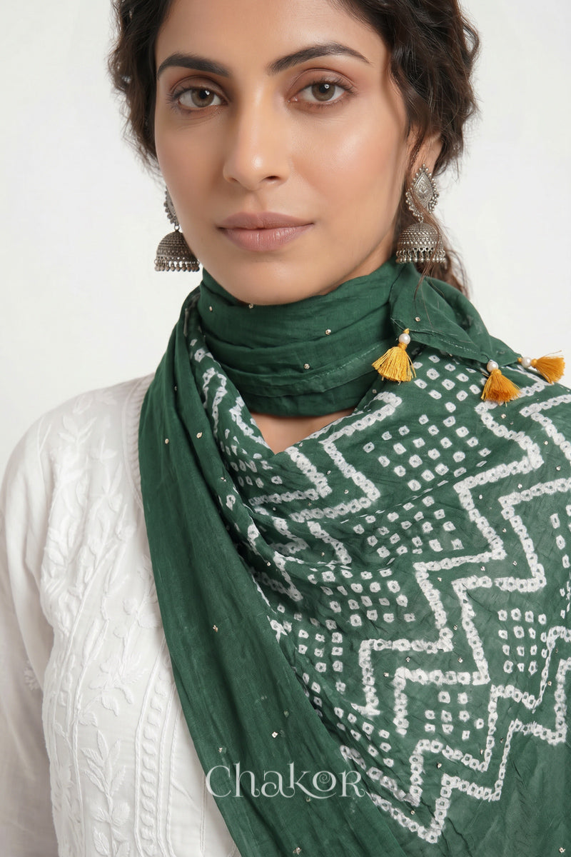 Moss green Kutch Bandhani mulmul dupatta wrapped around woman's neck.

