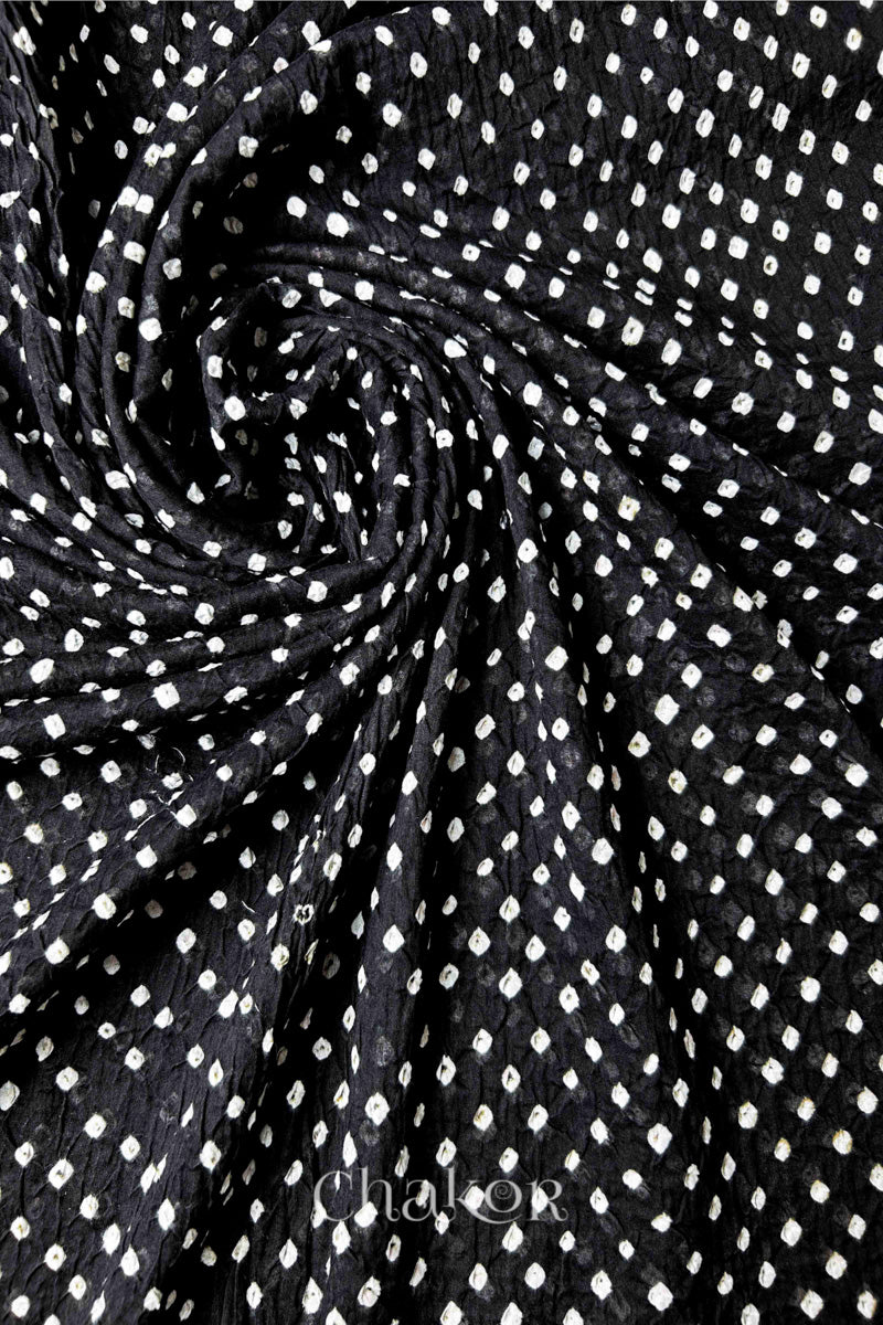 Chakor's black cotton bandhani dupatta | chunri featuring white dots, arranged in a swirling design.