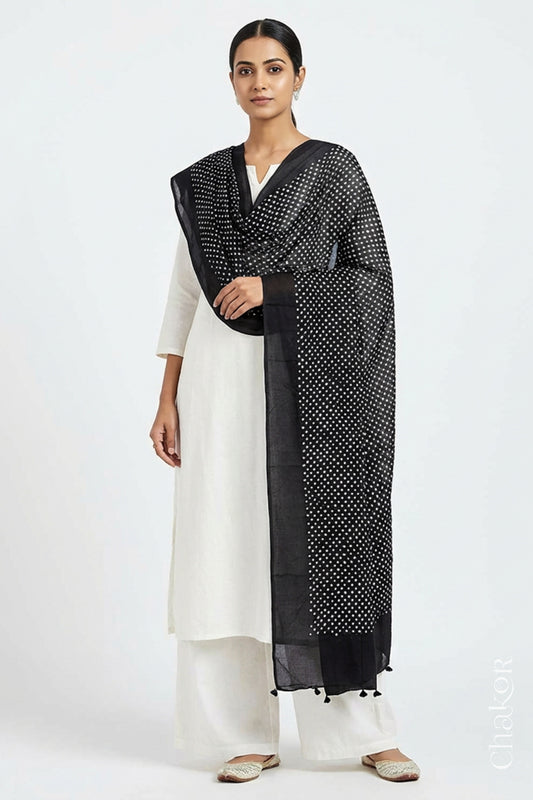 Model wearing Black Bandhani mul cotton dupatta with tie-dye dot pattern draped over a white kurta.
