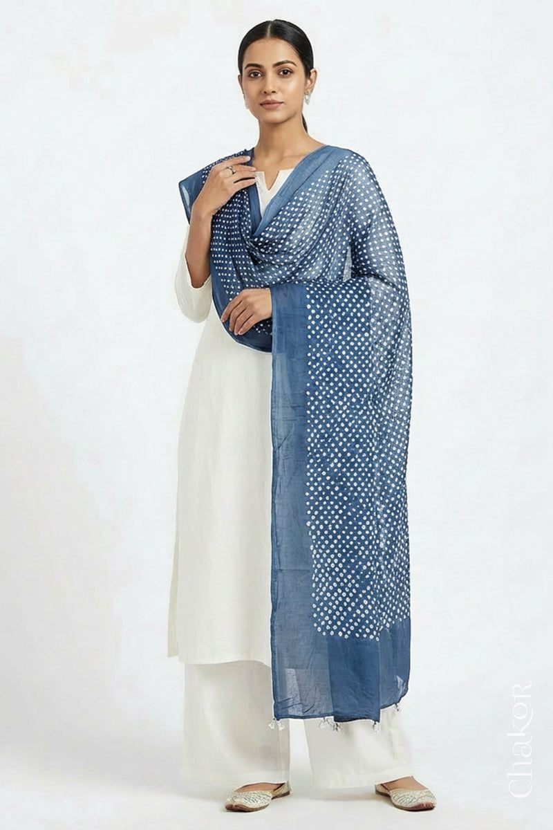 Model wearing Blue grey Bandhani mul cotton dupatta with tie-dye dot pattern draped over a white kurta.