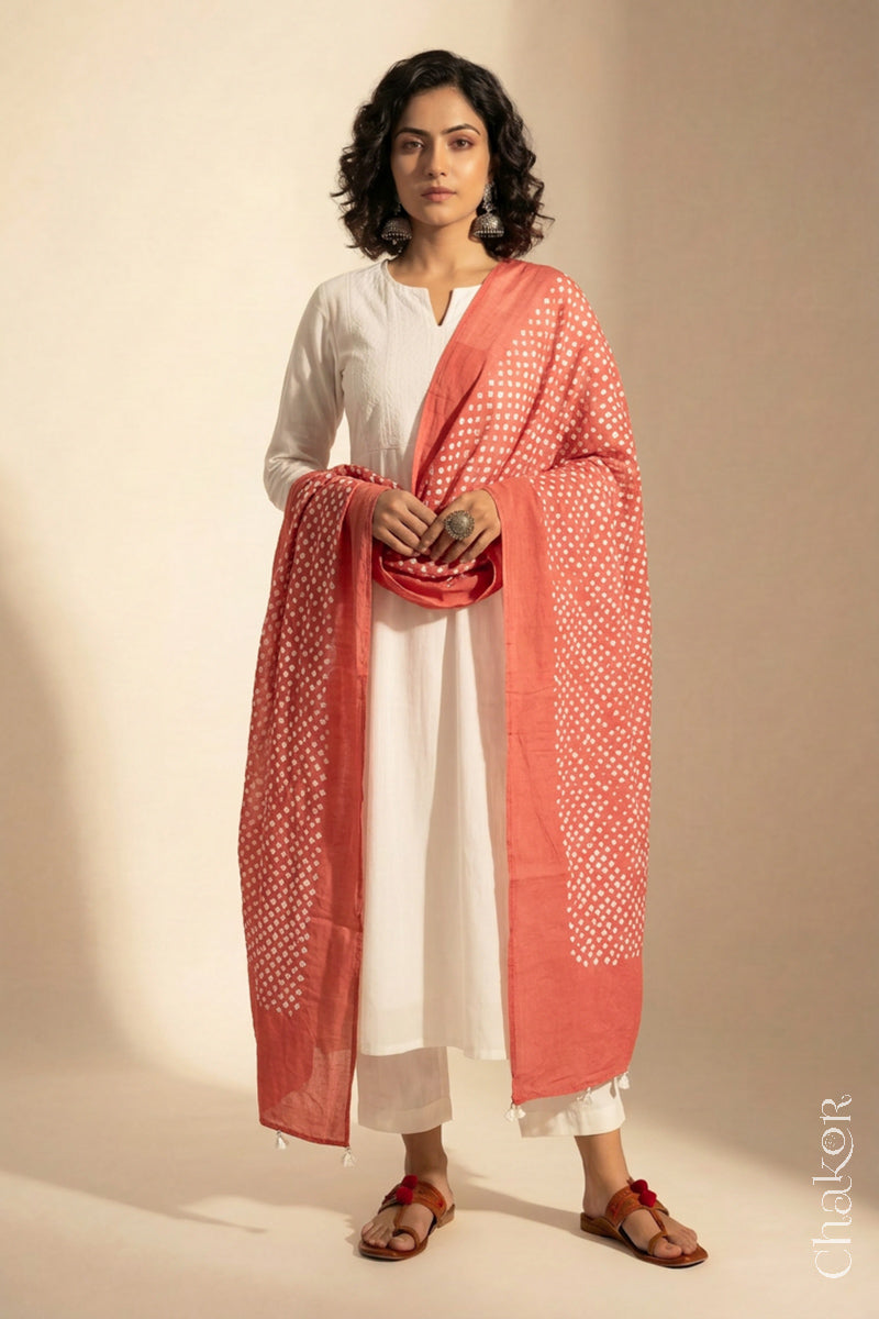 Model wearing Dark Peach Bandhani mul cotton dupatta with tie-dye dot pattern draped over a white kurta.

