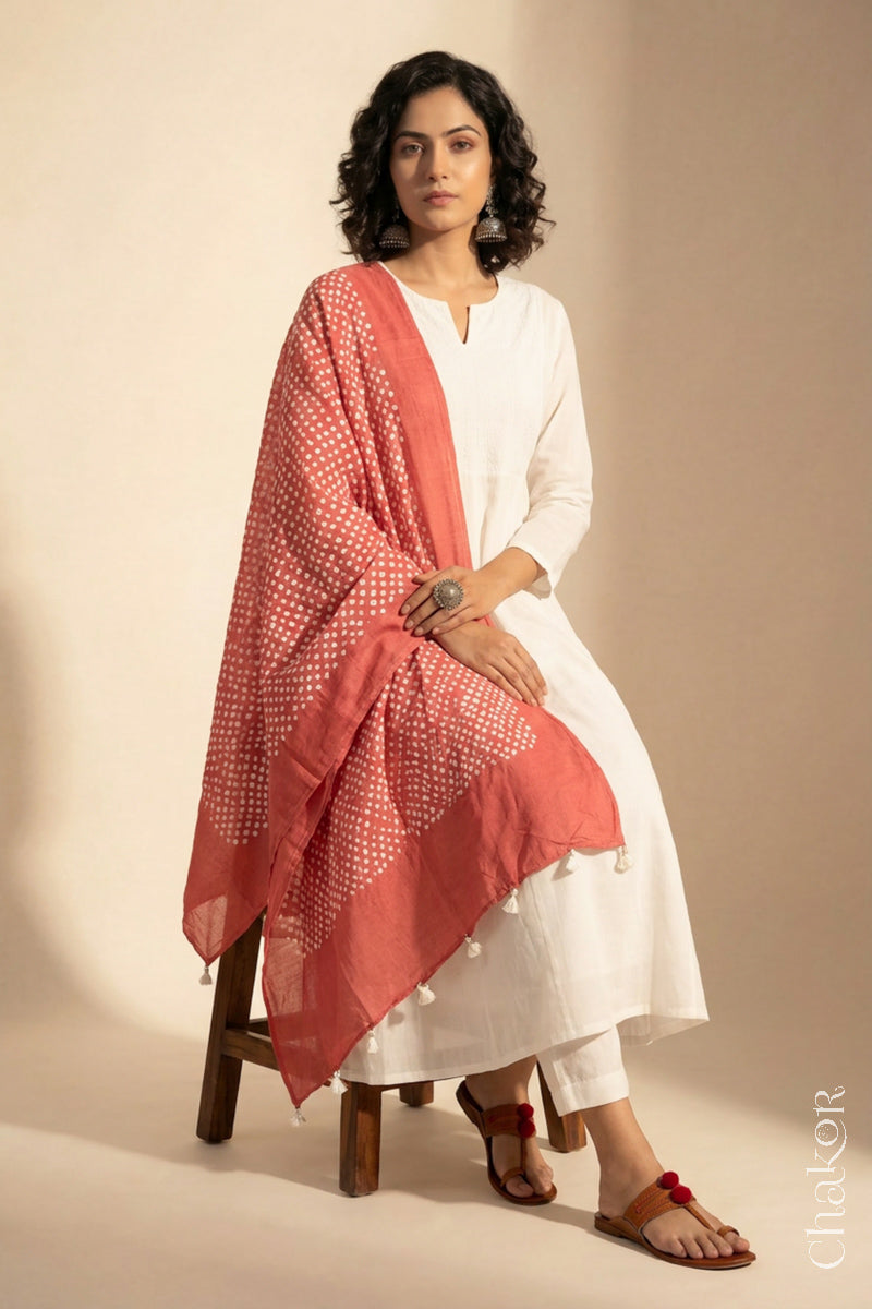 Model wearing Dark Peach Bandhani mul cotton dupatta with tie-dye dot pattern draped over a white kurta.
