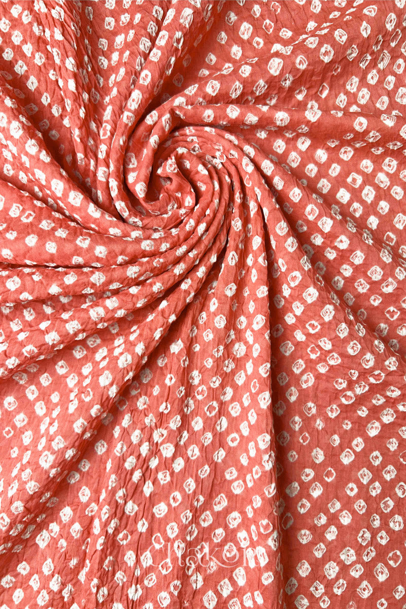Detail view of Dark Peach Bandhani mul cotton dupatta highlighting tie-dye dots arranged in spiral drape.
