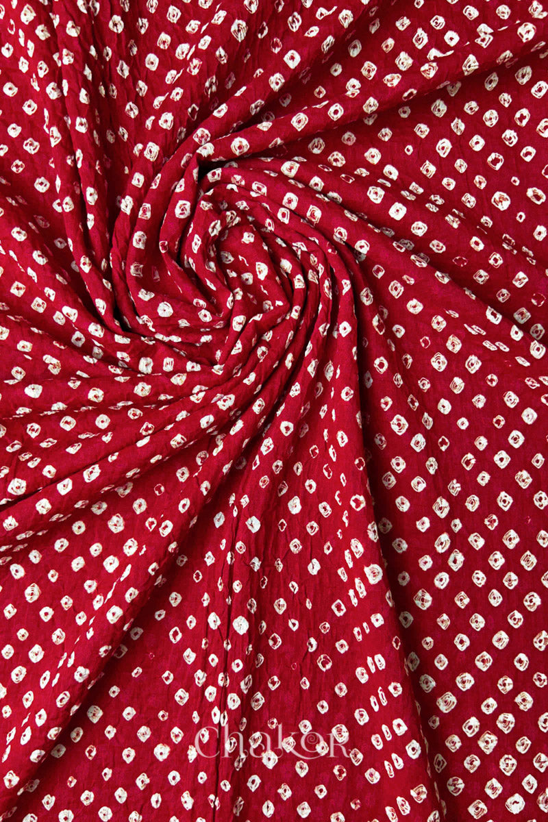 Chakor's red cotton bandhani dupatta | chunri featuring white dots, arranged in a swirling design.