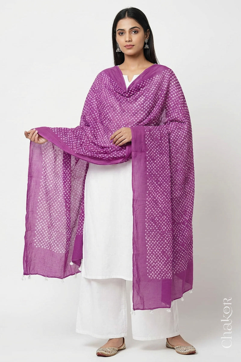 Model wearing Violet purple Bandhani mul cotton dupatta with tie-dye dot pattern draped over a white kurta.
