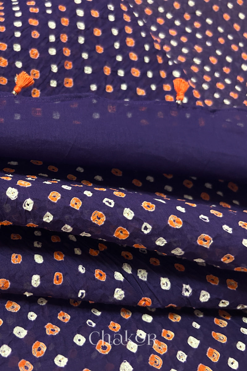 Close up of Authentic Purple Bandhani dupatta featuring handmade tassels and dense white & orange tie-dye dot pattern by CHAKOR.