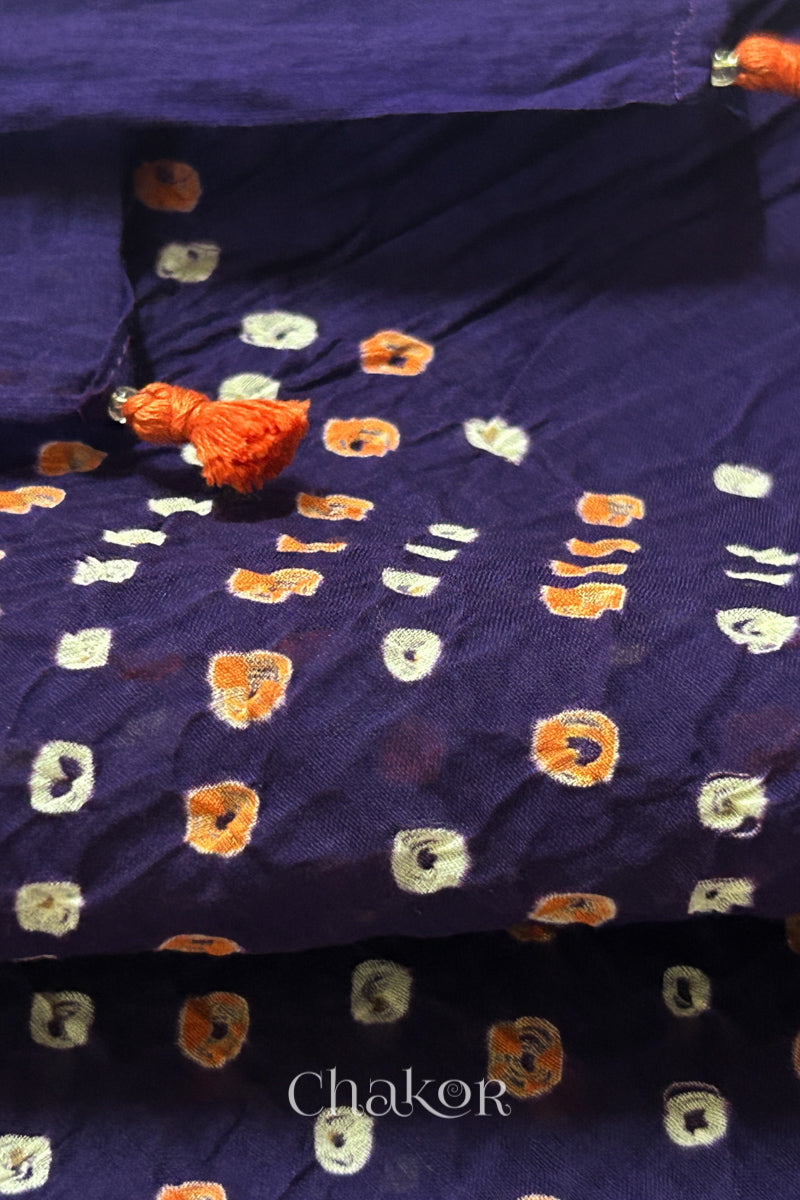 Close up of Authentic Purple Bandhani dupatta featuring handmade tassels and dense white & orange tie-dye dot pattern by CHAKOR.