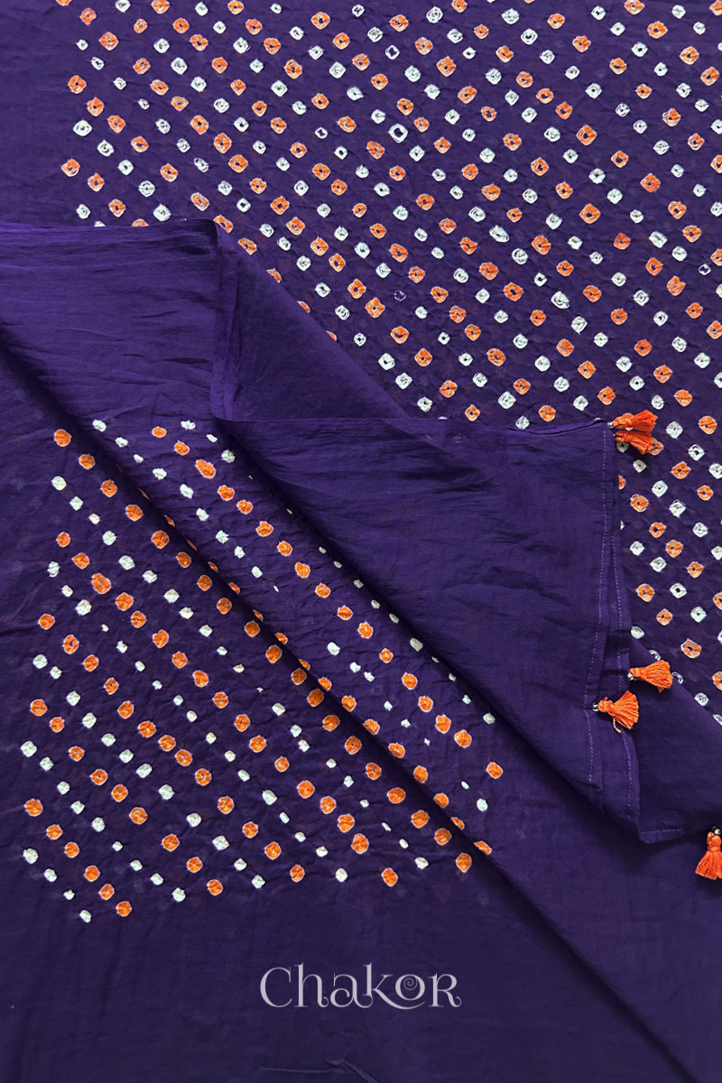 Close up of Authentic Purple Bandhani dupatta featuring handmade tassels and dense white & orange tie-dye dot pattern by CHAKOR.