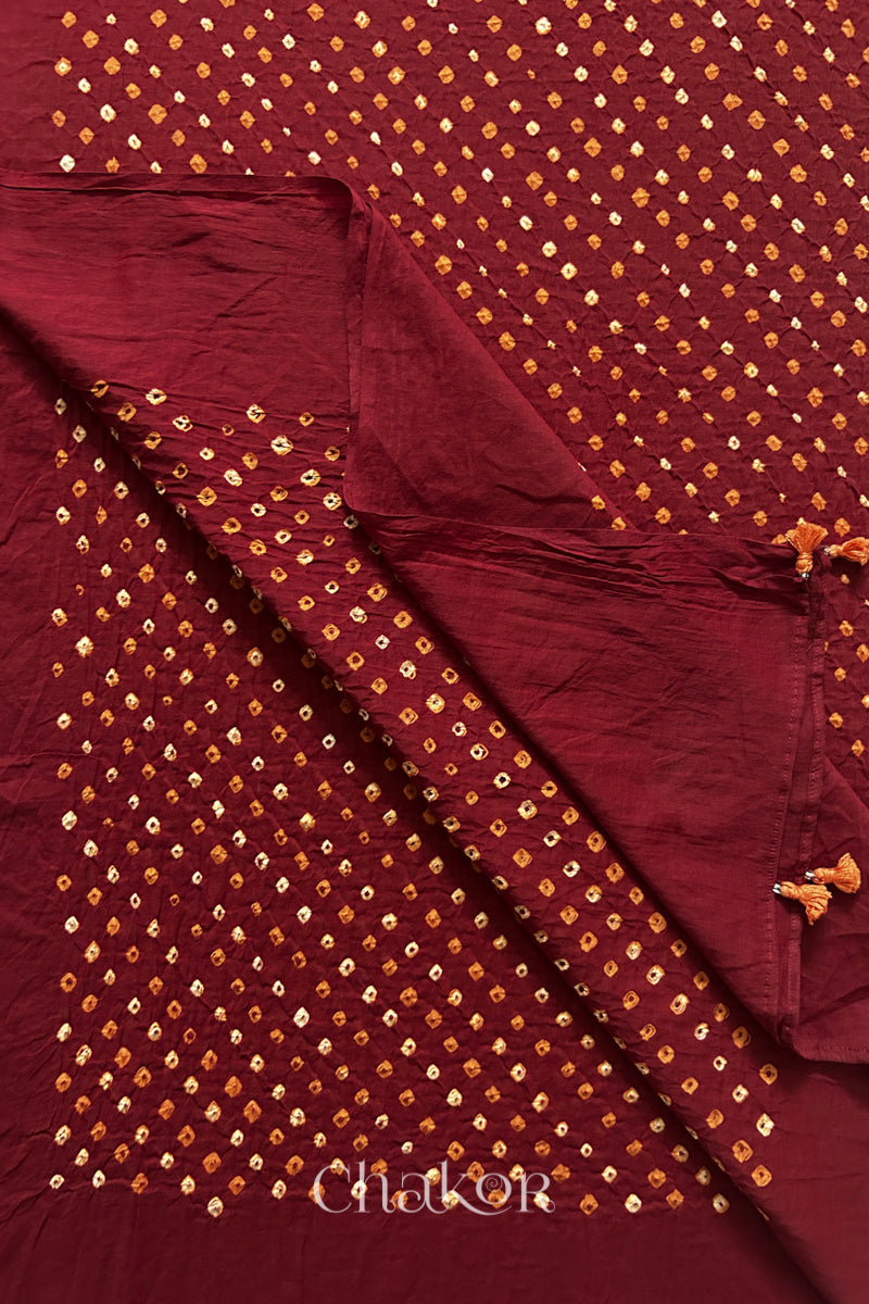 Close up of Authentic Kutch Bandhani dupatta in Red featuring handmade tassels and dense white & orange tie-dye dot pattern by CHAKOR.