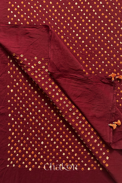 Close up of Authentic Kutch Bandhani dupatta in Red featuring handmade tassels and dense white & orange tie-dye dot pattern by CHAKOR.