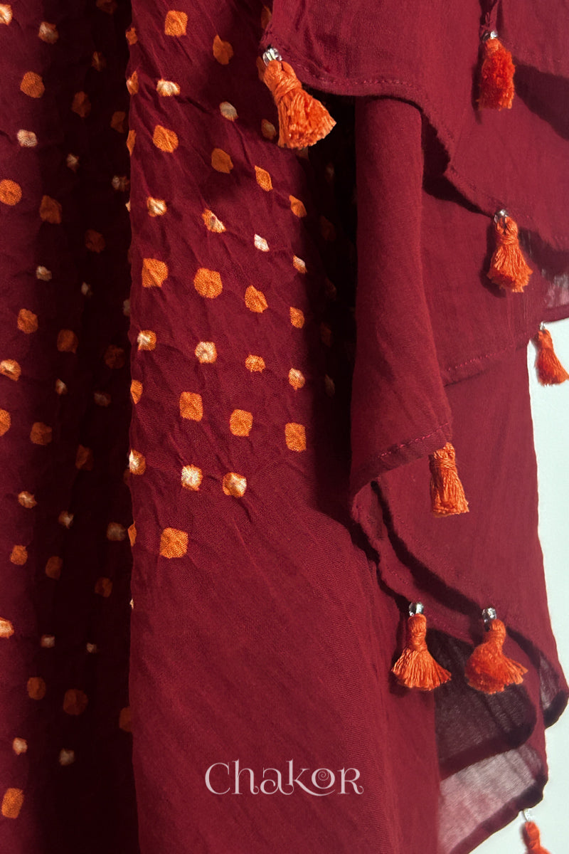 Close up of Authentic Red Bandhani dupatta featuring handmade tassels and dense white & orange tie-dye dot pattern by CHAKOR.