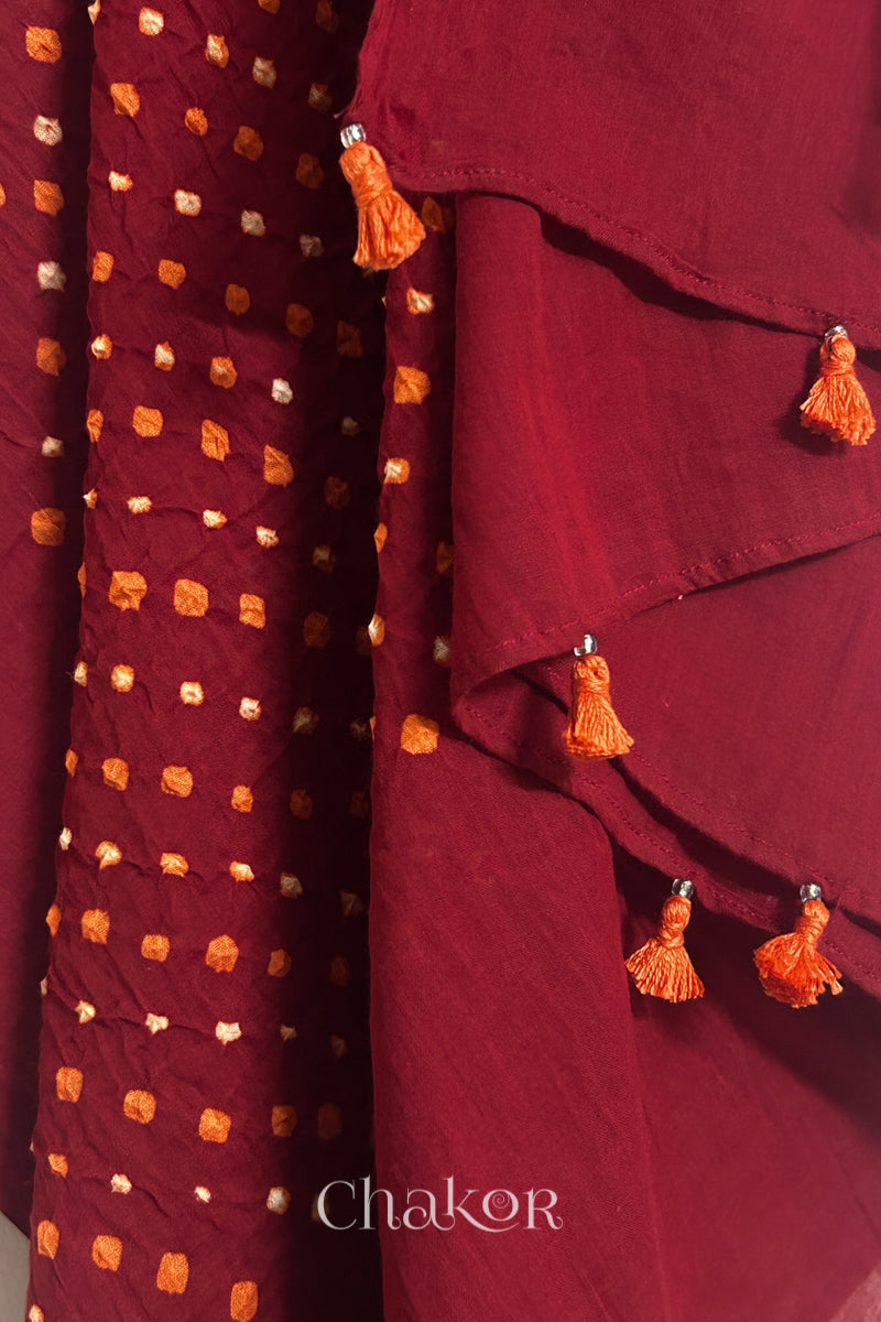 Close up of Authentic Red Bandhani dupatta featuring handmade tassels and dense white & orange tie-dye dot pattern by CHAKOR.