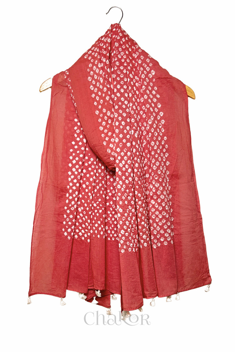 Dusty Red Bandhani mul cotton dupatta draped on hanger showing tie-dye dot pattern and tasselled edge.