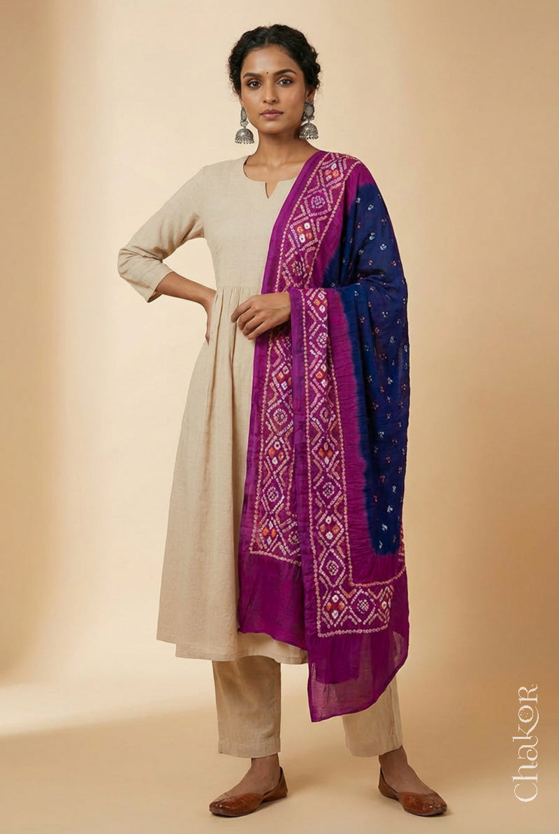 Model wearing navy and magenta Bandhani mul cotton dupatta with tie-dye dot pattern paired with a white kurta.