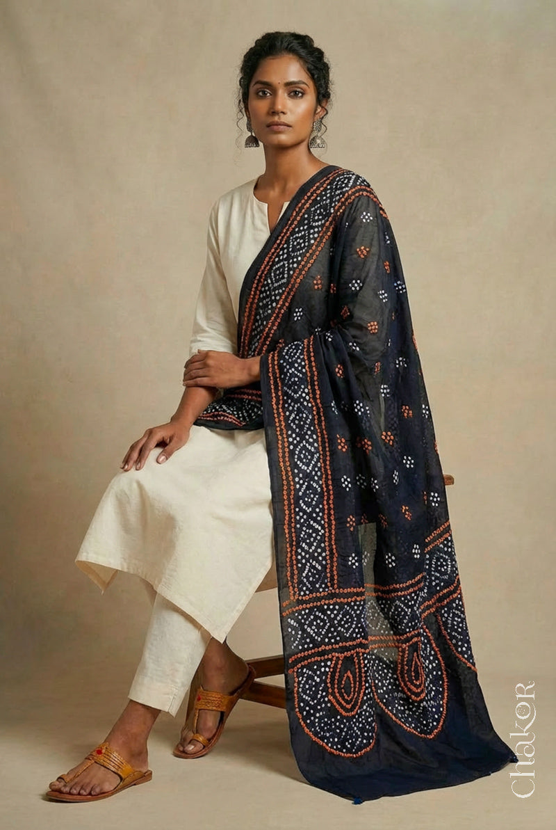 Model wearing black Bandhani mul cotton dupatta with tie-dye dot pattern paired with a white kurta.