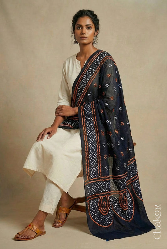 Model wearing black Bandhani mul cotton dupatta with tie-dye dot pattern paired with a white kurta.