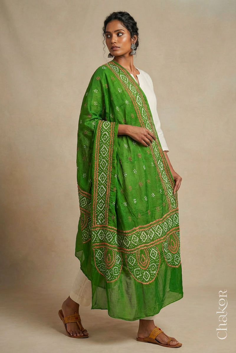 Model wearing mehendi Bandhani mul cotton dupatta with tie-dye dot pattern paired with a white kurta.