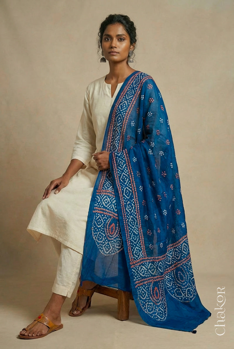 Model wearing indigo Bandhani mul cotton dupatta with tie-dye dot pattern paired with a white kurta.