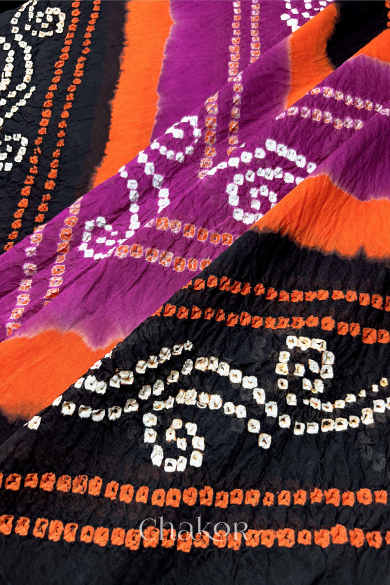 Close-up of magenta and black Bandhani mul cotton dupatta showing tie-dye dots and diagonal colour bands.