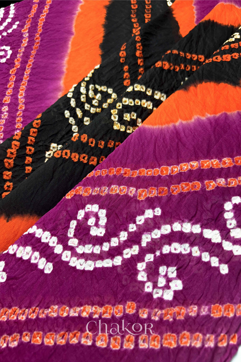 Close-up of magenta and black Bandhani mul cotton dupatta showing tie-dye dots and diagonal colour bands.