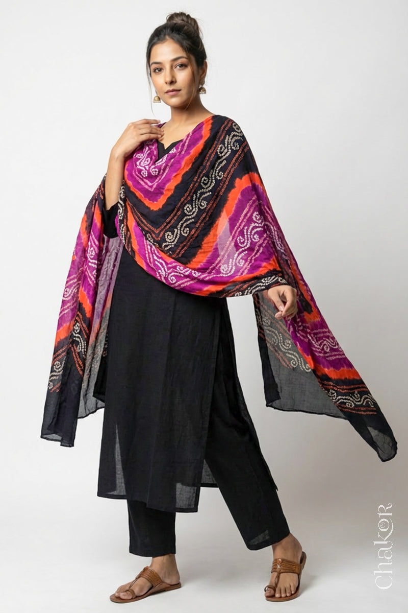Model wearing black magenta mul cotton Bandhani dupatta with multicolour tie-dye dots and striped bands draped over a black kurta.