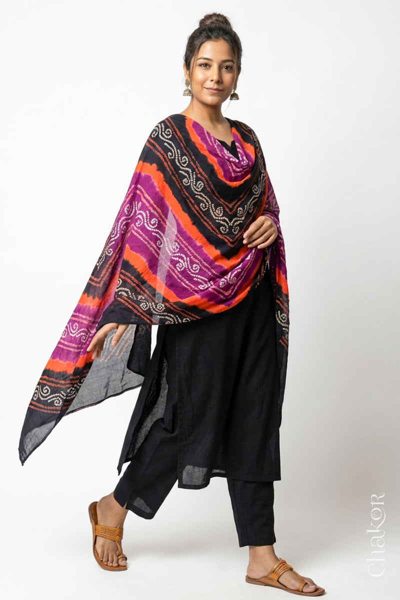 Model wearing black magenta mul cotton Bandhani dupatta with multicolour tie-dye dots and striped bands draped over a black kurta.
