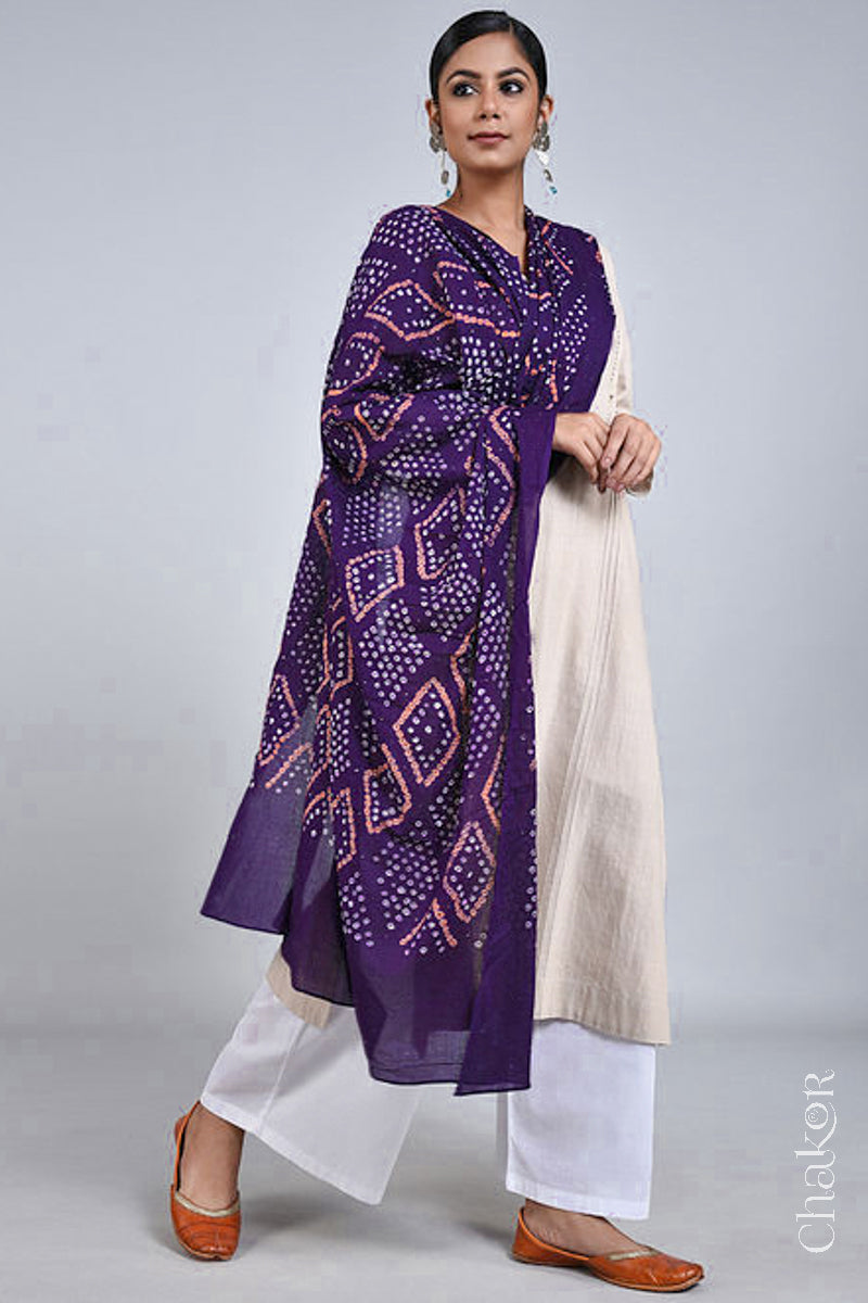 Model wearing a Purple Bandhani mul cotton dupatta with traditional Chorkat diamond pattern from CHAKOR, draped over an ivory kurta set.