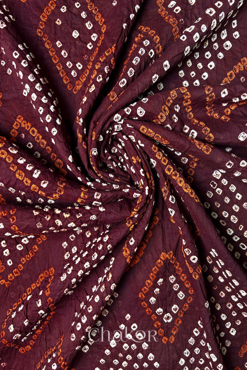 Swirl shot showing Bandhani dot clusters and diamond motifs on Maroon Mul Cotton Dupatta by Chakor.
